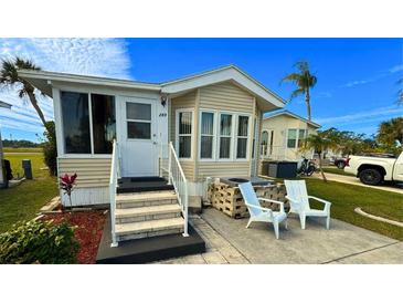 Inviting exterior of a manufactured home with landscaped yard and seating area at 289 Bainbridge Dr, Nokomis, FL 34275