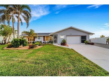 Single-story home with landscaped yard, driveway, and attached garage at 4430 Wynkoop Cir, Port Charlotte, FL 33948