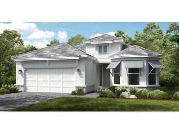 White two-story house with gray roof, landscaping, and two-car garage at 8040 Moonbeam Avenue, Sarasota, FL 34241