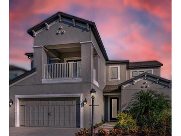 Two-story house with gray siding, balcony, and three-car garage at 8273 Shooting Star Rd, Sarasota, FL 34241