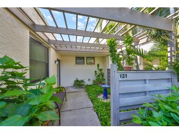 Inviting patio with pergola, lush landscaping, and a bird bath at 131 Pinehurst Dr # 131, Bradenton, FL 34210
