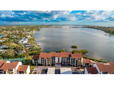 Aerial view of waterfront condo building with tennis courts and water access at 1608 Stickney Point Rd # 1608-102, Sarasota, FL 34231