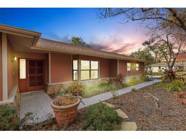 Charming home featuring a welcoming entrance, well-manicured landscaping, and a beautiful walkway at 2218 Shadow Oaks Rd, Sarasota, FL 34240