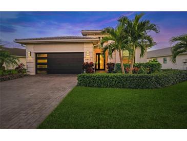 Attractive house exterior featuring a modern design, two-car garage, and landscaping at 4947 Surfside Cir, Bradenton, FL 34211