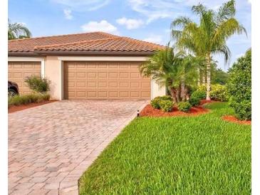 Two-car garage with paver driveway and landscaped lawn at 6680 Willowshire Way, Bradenton, FL 34212