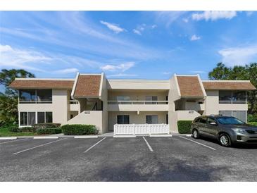 Front view of condo building, with parking and landscaping at 7304 W Country Club N Dr # 213, Sarasota, FL 34243