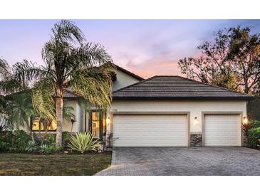 Two-story home with tile roof, two-car garage, and landscaped yard at 7728 Rio Bella Pl, Bradenton, FL 34201