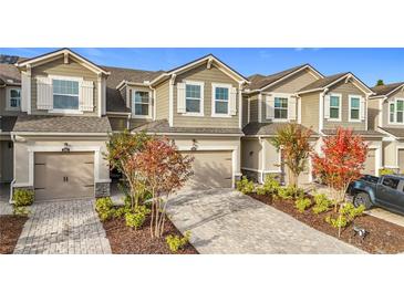 Three-unit townhome complex with attached garages and landscaped yards at 12455 Trailhead Dr, Bradenton, FL 34211