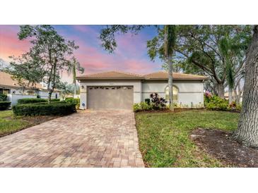 Well-maintained house with a brick driveway, and lush landscaping at 3339 Highlands Bridge Rd # 65, Sarasota, FL 34235