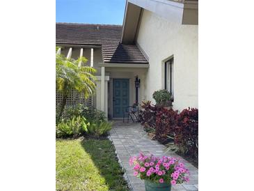 Inviting front entrance with teal door and well-manicured landscaping at 3354 Sandleheath # 13, Sarasota, FL 34235