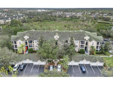 Aerial view of condo building, showing building, parking lot and landscaping at 5180 Northridge Rd # 211, Sarasota, FL 34238