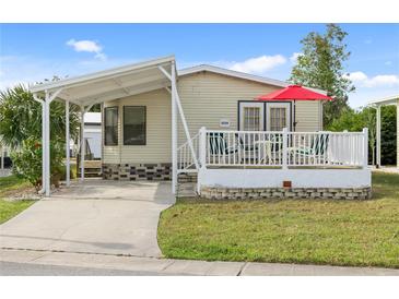 Single-wide manufactured home with carport and covered deck at 5539 Holiday Park Blvd, North Port, FL 34287