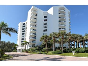 White building exterior, palm trees, and landscaping at 1000 Longboat Club Rd # 304, Longboat Key, FL 34228