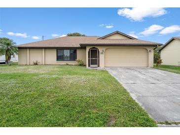 Single-story home with attached garage and well-manicured lawn at 1170 Richter St, Port Charlotte, FL 33952