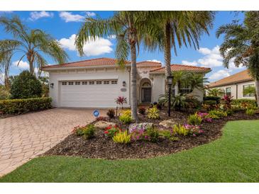 Single-story home with white walls, tile roof, and landscaped front yard at 14614 Newtonmore Ln, Lakewood Ranch, FL 34202