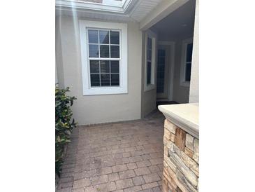 Inviting front porch with brick pavers and stone accents at 1910 Scarlett Ave, North Port, FL 34289