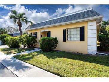 Front view of charming yellow house with manicured lawn at 2413 Aspinwall St # 2413, Sarasota, FL 34237