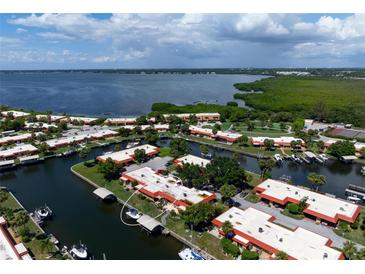 Aerial view of waterfront property with boat slips and lush landscaping at 4108 La Costa Cv, Bradenton, FL 34210