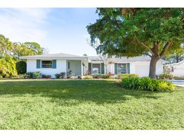 Ranch-style home with a large front yard and mature tree at 4515 Falcon Ridge Dr, Sarasota, FL 34233