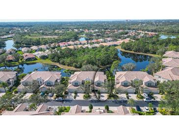 Stunning aerial view of the property showcasing its prime location with lake and lush landscaping at 5208 Parisienne Pl # 202B33, Sarasota, FL 34238