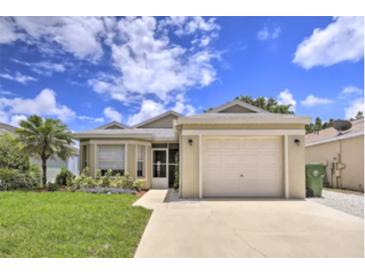 House exterior featuring a beige one-story home with a two-car garage and a well-maintained lawn at 6115 39Th W Ave, Bradenton, FL 34209