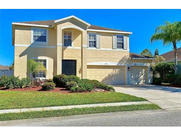 Two-story house with beige exterior, two-car garage, and landscaped lawn at 6172 42Nd Street E St, Bradenton, FL 34203