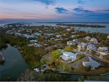 Aerial view of house nestled in a neighborhood near the water at 6821 Longboat S Dr, Longboat Key, FL 34228