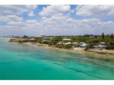 Aerial view of waterfront homes and clear, shallow ocean water at 7314 Point Of Rocks Rd, Sarasota, FL 34242