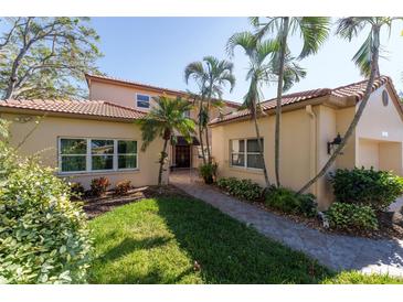 Beautiful two-story home with lush landscaping and a walkway to the entrance at 7503 Calle Facil, Sarasota, FL 34238