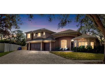 Two-story house with a stone facade, three-car garage, and landscaped yard at 2232 Elcid Ct, Palm Harbor, FL 34683