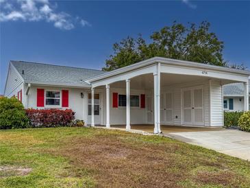 White house with red shutters, carport, and well-maintained lawn at 4714 Potomac Cir, Bradenton, FL 34210