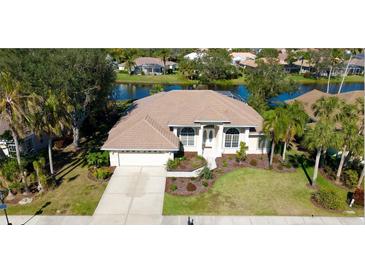 Single-Gathering home with lake view, two-car garage, and landscaped yard at 4821 Hanging Moss Ln, Sarasota, FL 34238