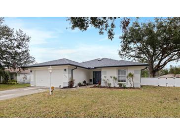 White house with gray roof, landscaping, and a two-car garage at 7664 39Th Street E Cir, Sarasota, FL 34243