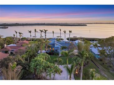 Aerial view of waterfront home with lush landscaping and private dock at 10106 46Th W Ave, Bradenton, FL 34210