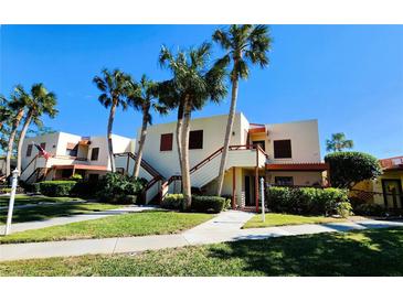 Tan two-story building with stairs, palm trees, and walkways at 514 Spring Lakes Blvd, Bradenton, FL 34210