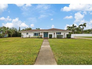 White single-story home with teal door and lush lawn at 5205 26Th W Ave, Bradenton, FL 34209