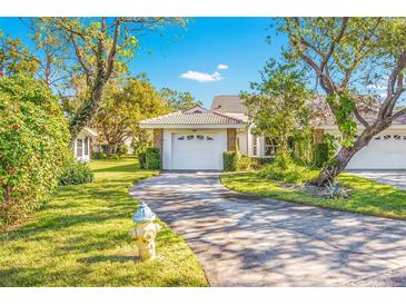 White brick home with attached garage and lush green lawn at 5803 Garden Lakes Palm, Bradenton, FL 34203