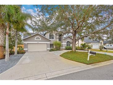 Two-story house with a gray exterior, paved driveway, and landscaping at 7737 40Th E Ct, Sarasota, FL 34243