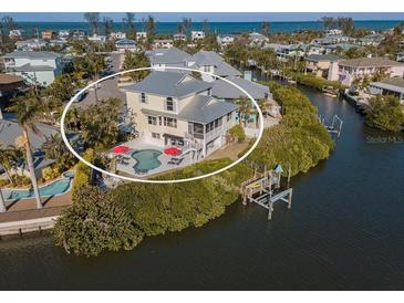 Aerial view of waterfront home with private pool and dock at 114 Gull Dr, Anna Maria, FL 34216