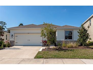 Charming single-story home with a well-manicured lawn and a two car garage on a sunny day at 2164 Midnight Pearl Dr, Sarasota, FL 34240