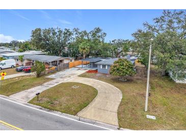 Aerial view of a single story home with a large driveway and mature trees at 3419 27Th Pkwy, Sarasota, FL 34235