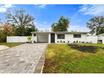 Updated home exterior boasts a paved driveway and landscaped lawn at 4042 Radnor Pl, Sarasota, FL 34233