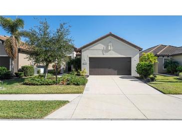Single-story home with a two-car garage and landscaped front yard at 491 Casalino Dr, Nokomis, FL 34275