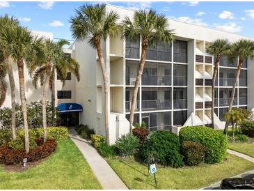 Exterior of condo building with palm trees and walkway at 6114 43Rd W St # 104E, Bradenton, FL 34210