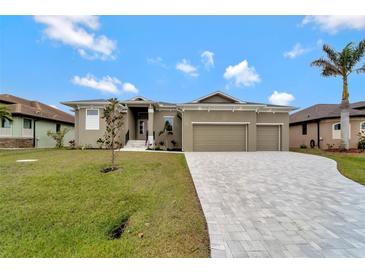 House exterior featuring a three-car garage and a paved driveway at 10508 Mcalester Cir, Port Charlotte, FL 33981