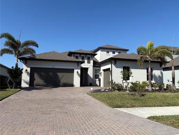 Beautiful single-Gathering home features a paver driveway, lush landscaping, and a two-car garage at 12571 Night View Dr, Sarasota, FL 34238