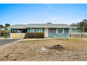 Charming coastal cottage with teal exterior, white trim, and landscaped yard at 1956 Massachusetts Ave, Englewood, FL 34224