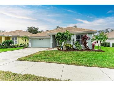 Single-story home with light gray exterior, tile roof, and landscaped lawn at 2831 Whispering Pine Ln, North Port, FL 34287