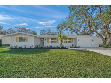 White house with wood accents, landscaped lawn, and driveway at 3054 Markridge Rd, Sarasota, FL 34231