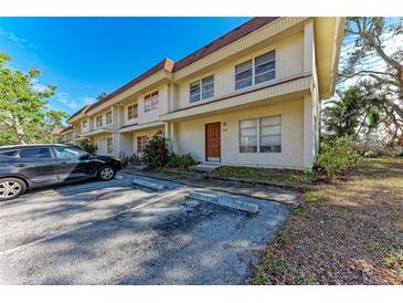 Tan two-story building with parking and landscaping at 318 Barlow Ave # 71, Sarasota, FL 34232